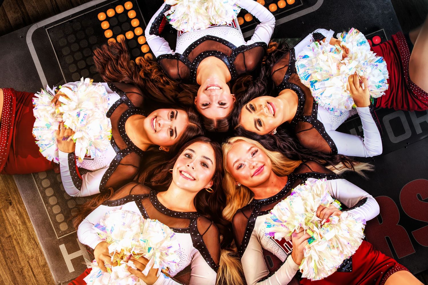 Overhead view of group wearing matching outfits lying in circle formation.