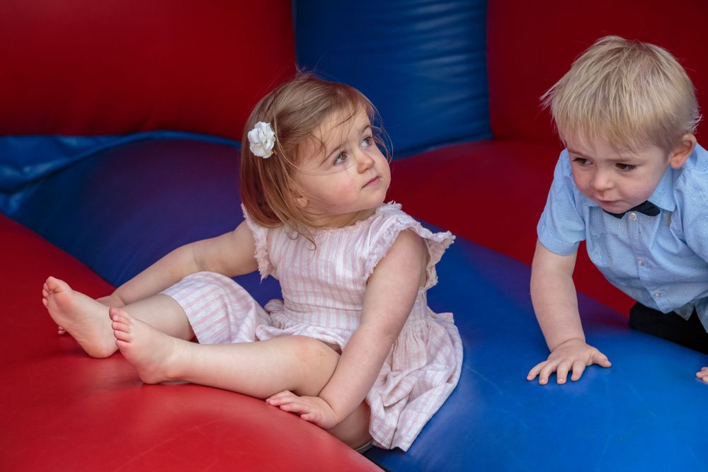 young girl and boy on the bouncy castle in the gardens at west tower