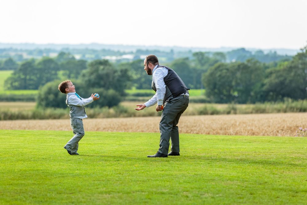page boy playing catch with one other ushers in the west tower gardens