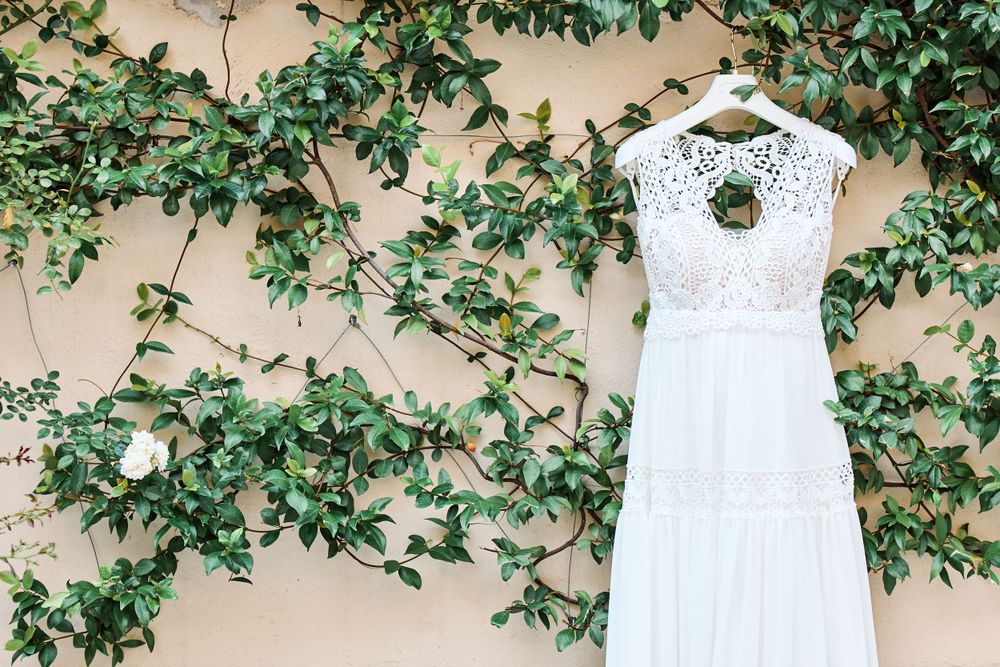 vestito bianco da sposa appeso all'edera verde
