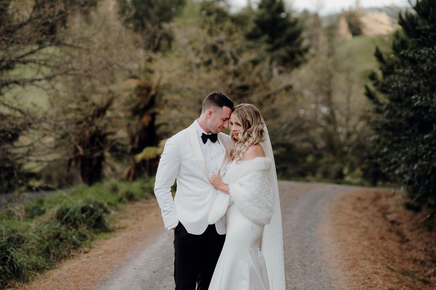 bride and groom embracing on driveway