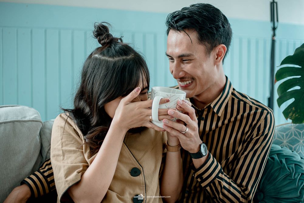 Candid moment of laughter and joy shared over coffee in a cozy living room setting.