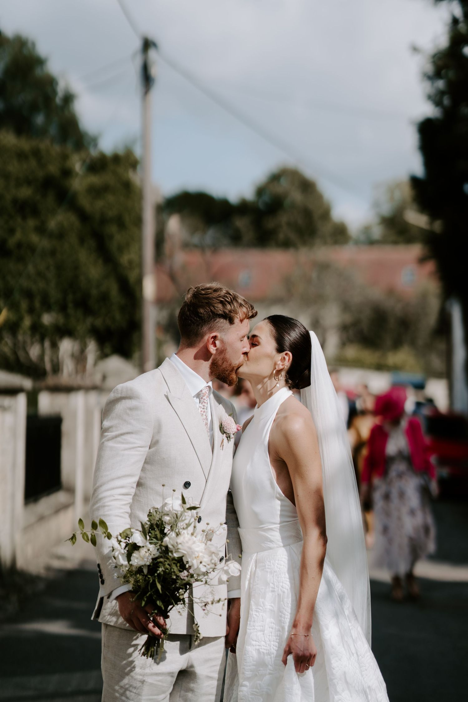 bride and groom kissing on their walk from st Nicholas church in islip to their marquee in oxfordshire