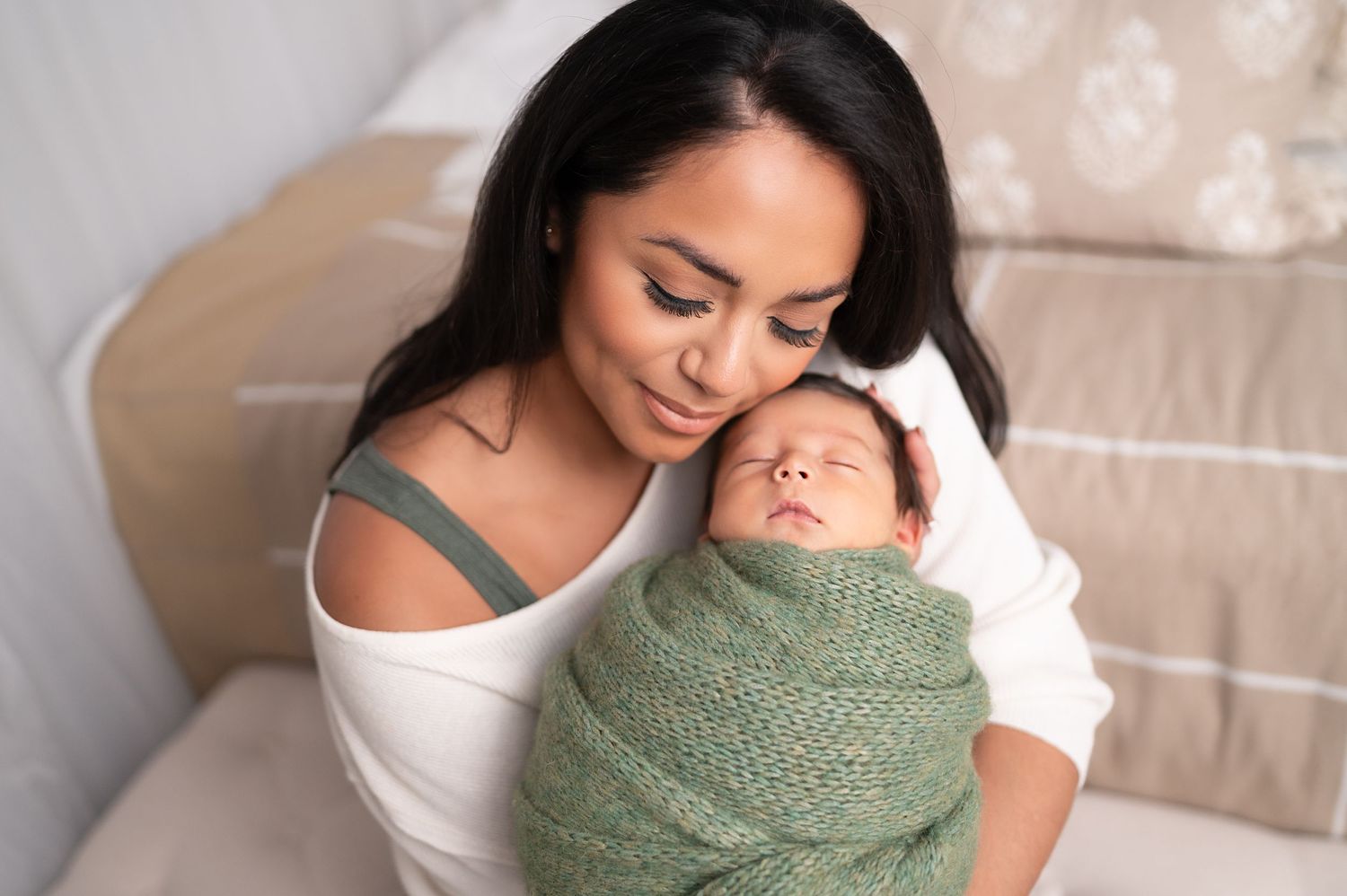 Elegant family portrait session on cream backdrop features tender moments with newborn.
