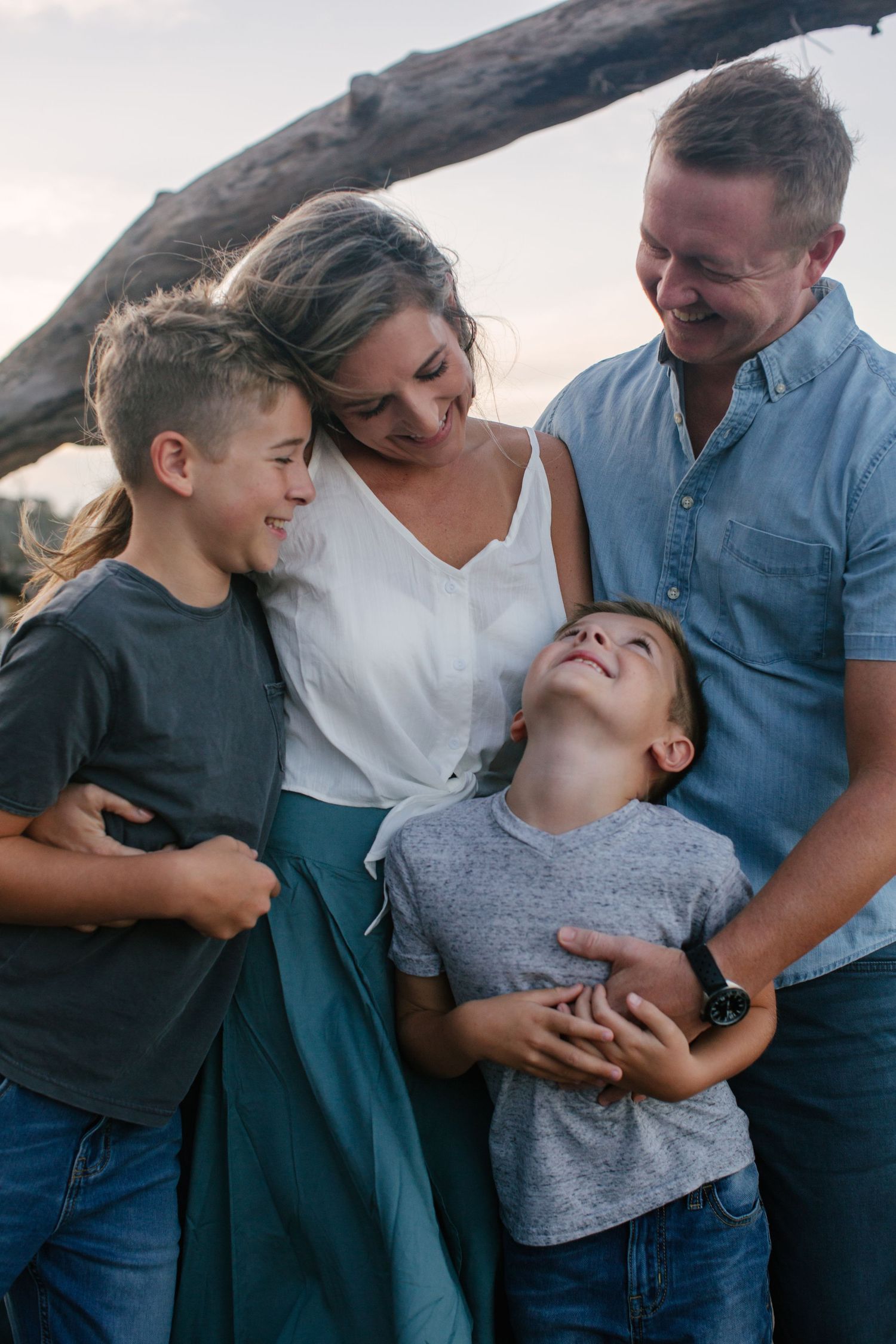 A joyful family sharing laughter together outdoors during a casual photo session.