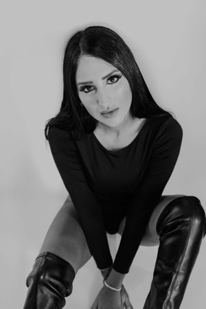 Artistic black and white fashion portrait featuring dramatic lighting and dark clothing.