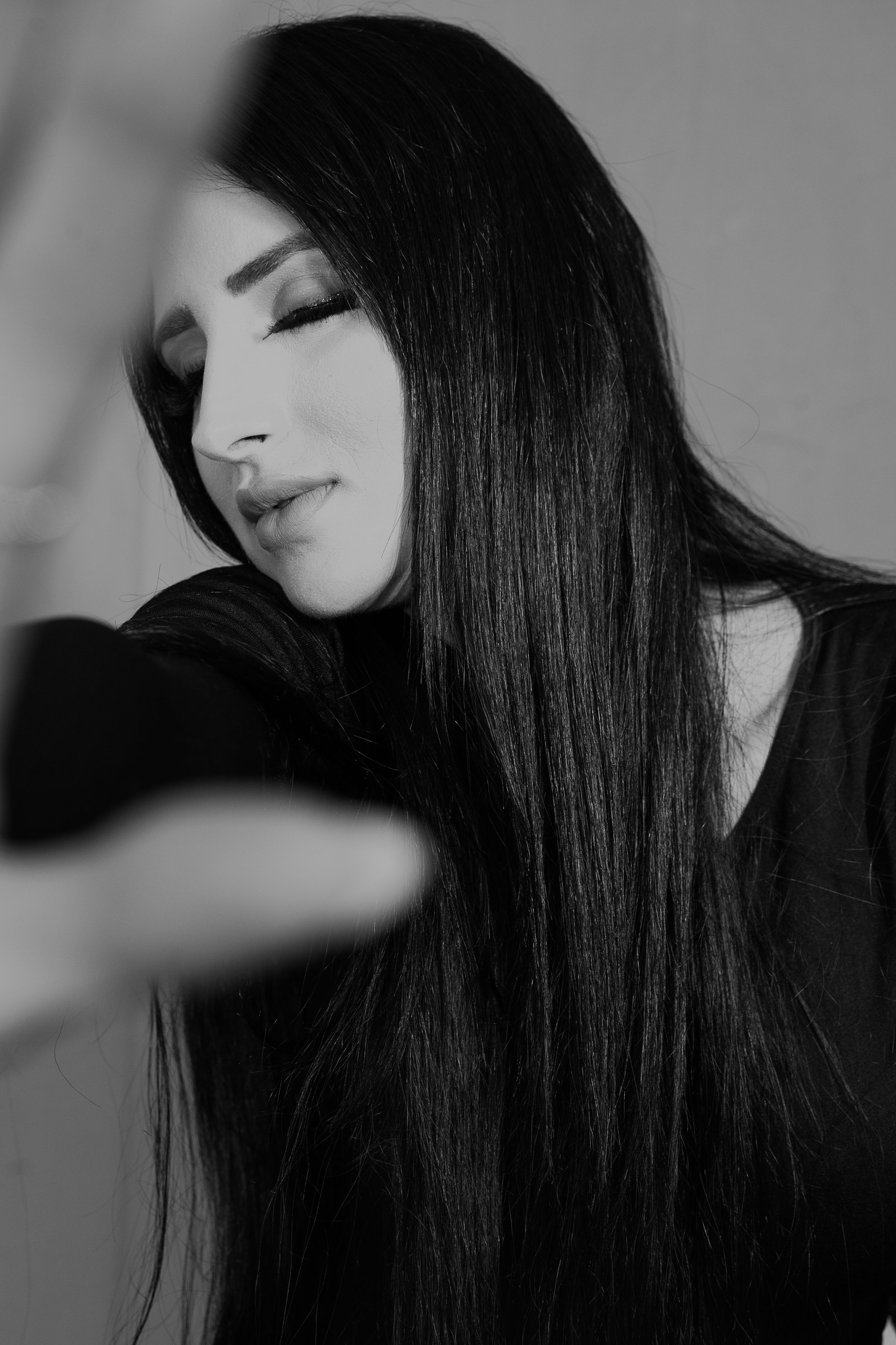 Black and white close-up of long dark hair with dramatic side lighting.