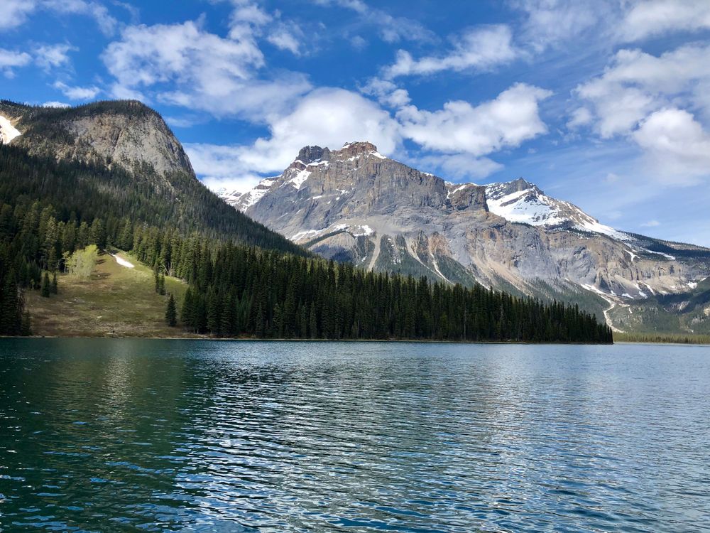 Panoramic view of a pristine mountain lake surrounded by snow-capped peaks.