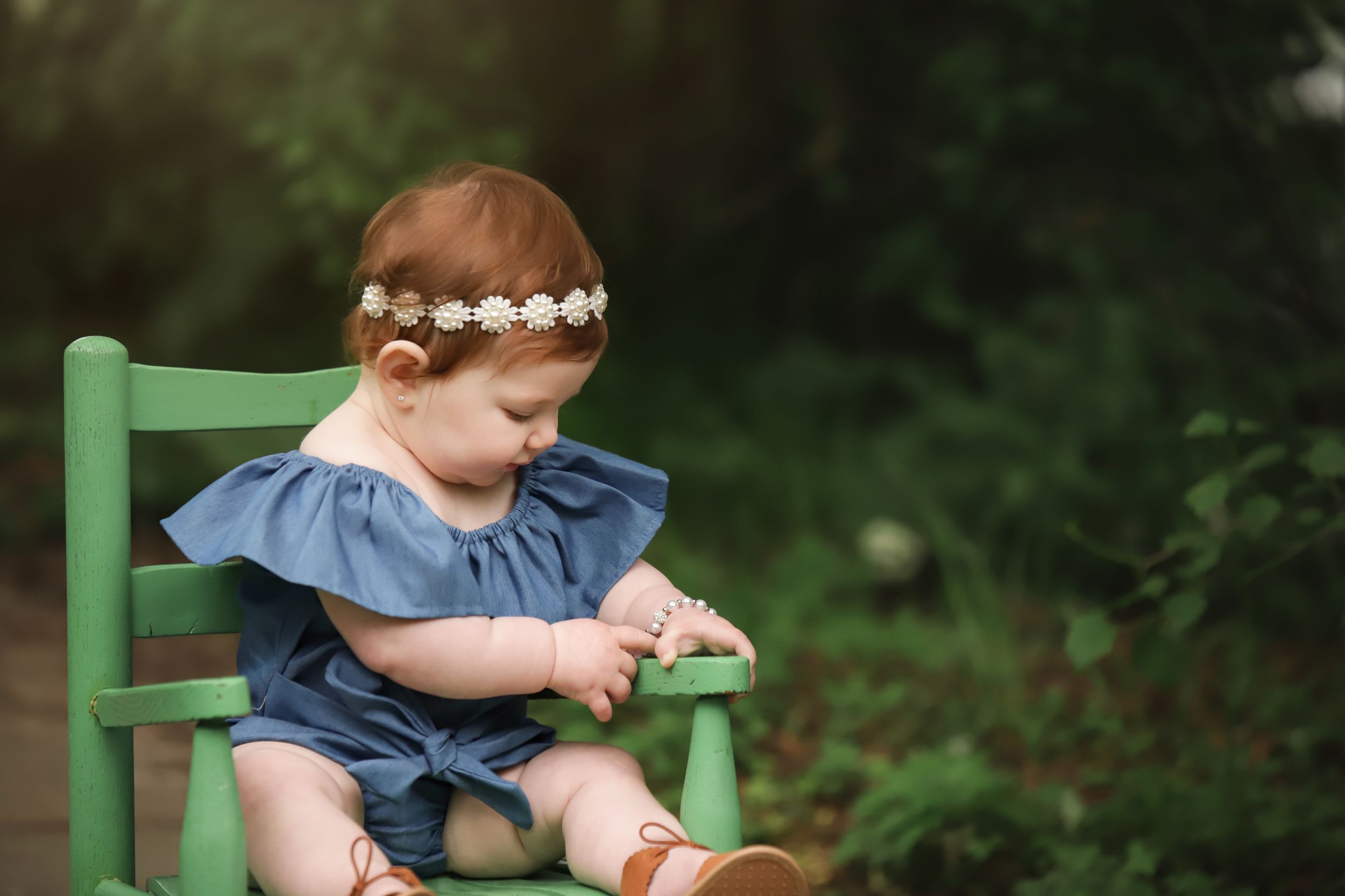 fine art milestone outdoor portrait with baby girl in spring in chair prop