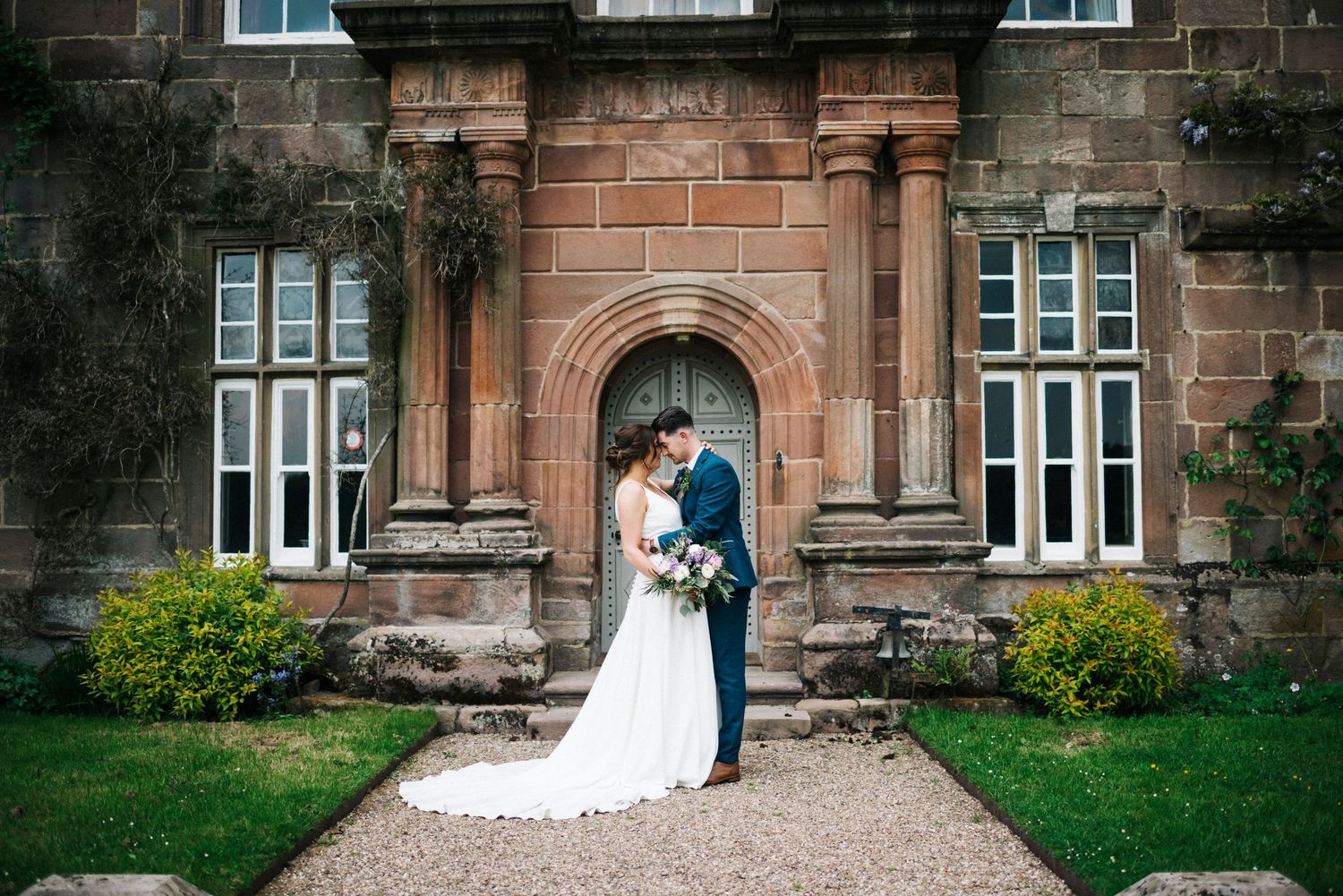 Wedding photography at historic stone mansion with classic architecture and manicured grounds.