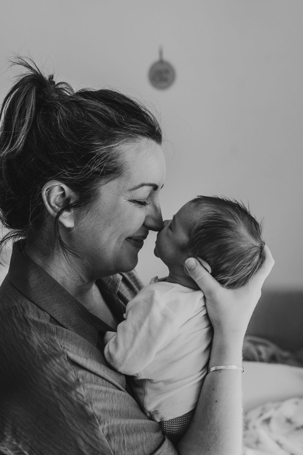 Black and white portrait of tender moment between parent and infant.