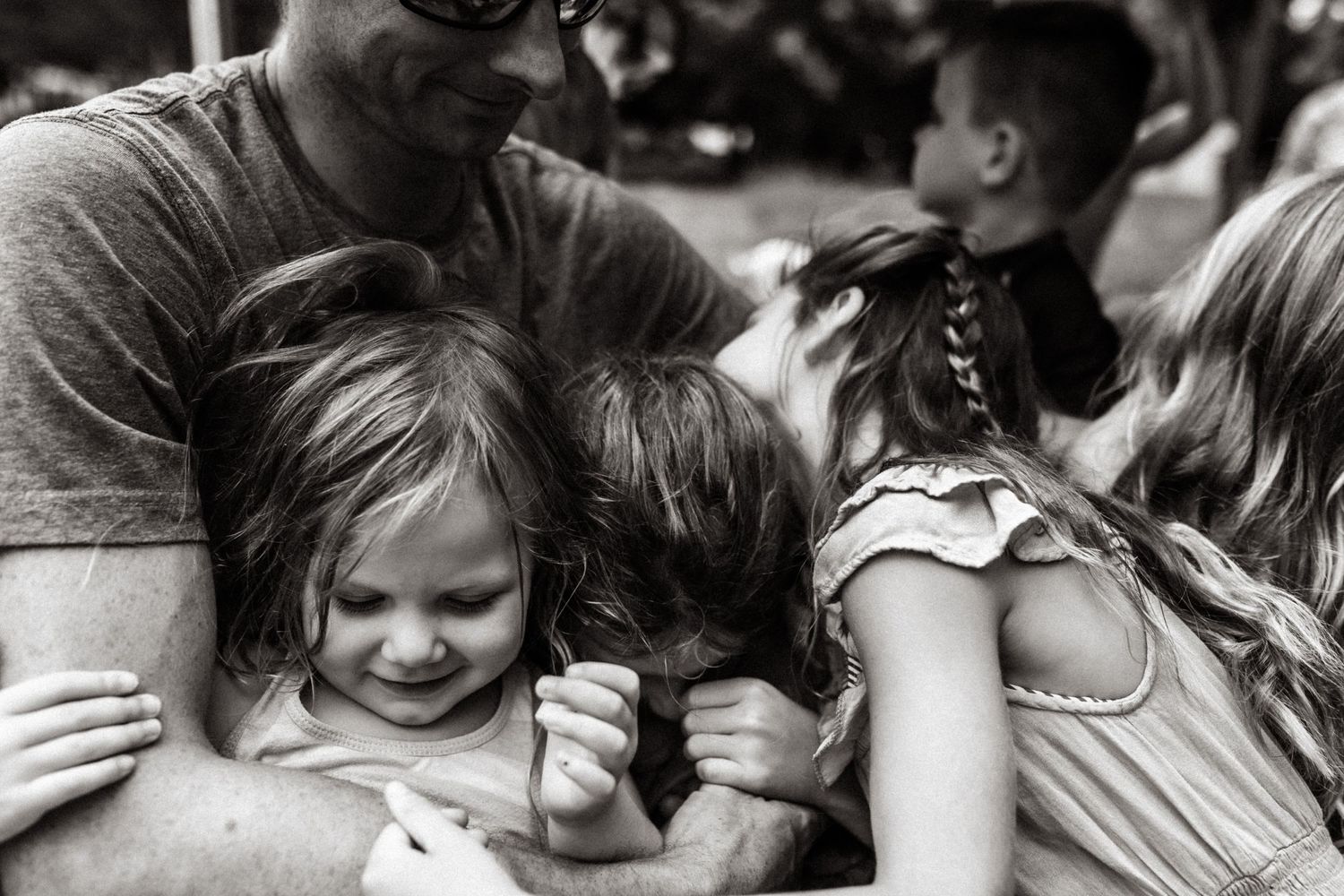 dad holding his daughters and embracing them on a golf cart on the eastern shore