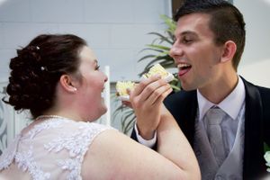 Couple shares cake during their wedding reception.