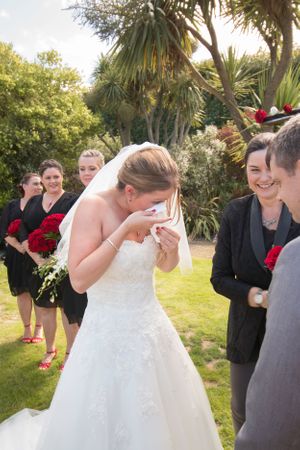A joyful moment during an outdoor garden wedding ceremony with tropical plants in the background.