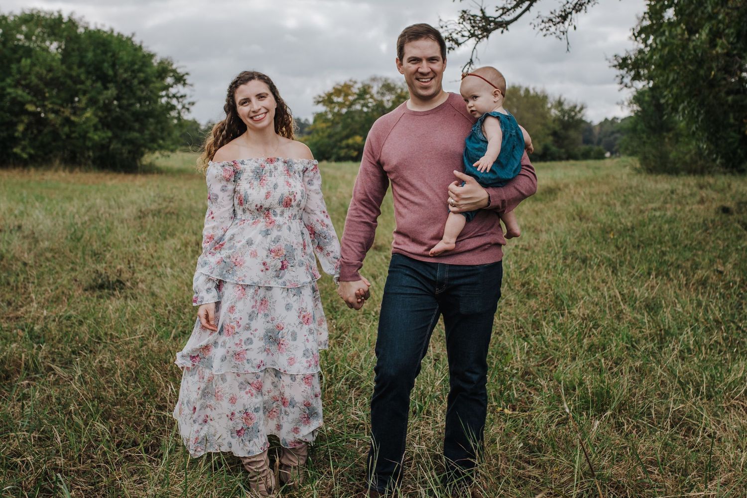 Family of three in a field by white rock lake
