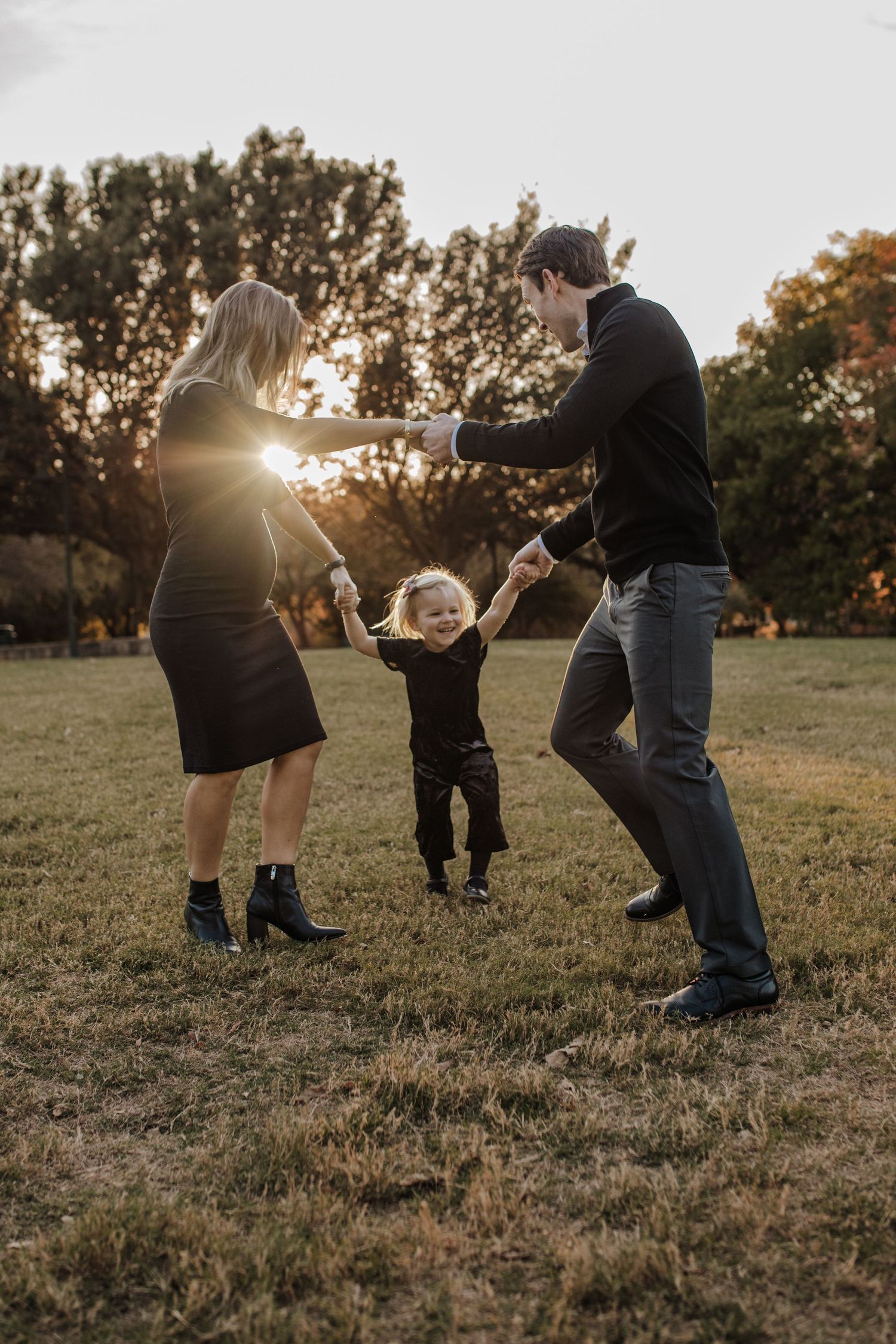 Family of three playing ring around the rosy in frisco