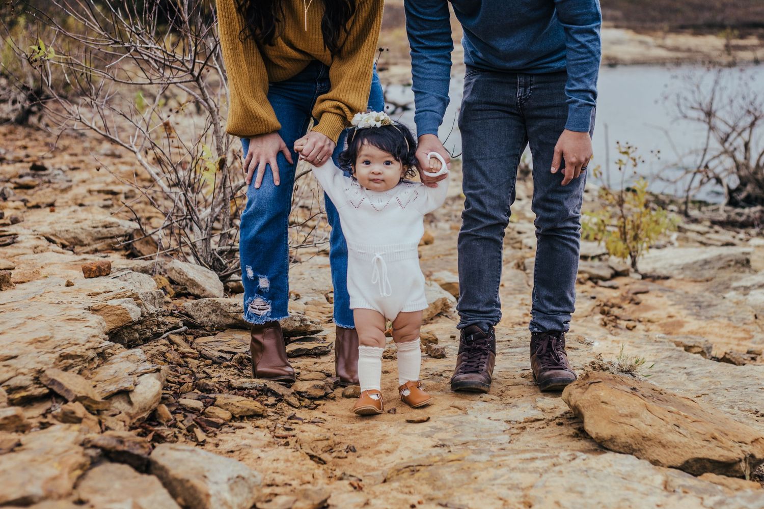 family of three standing with one year old by lake grapevine