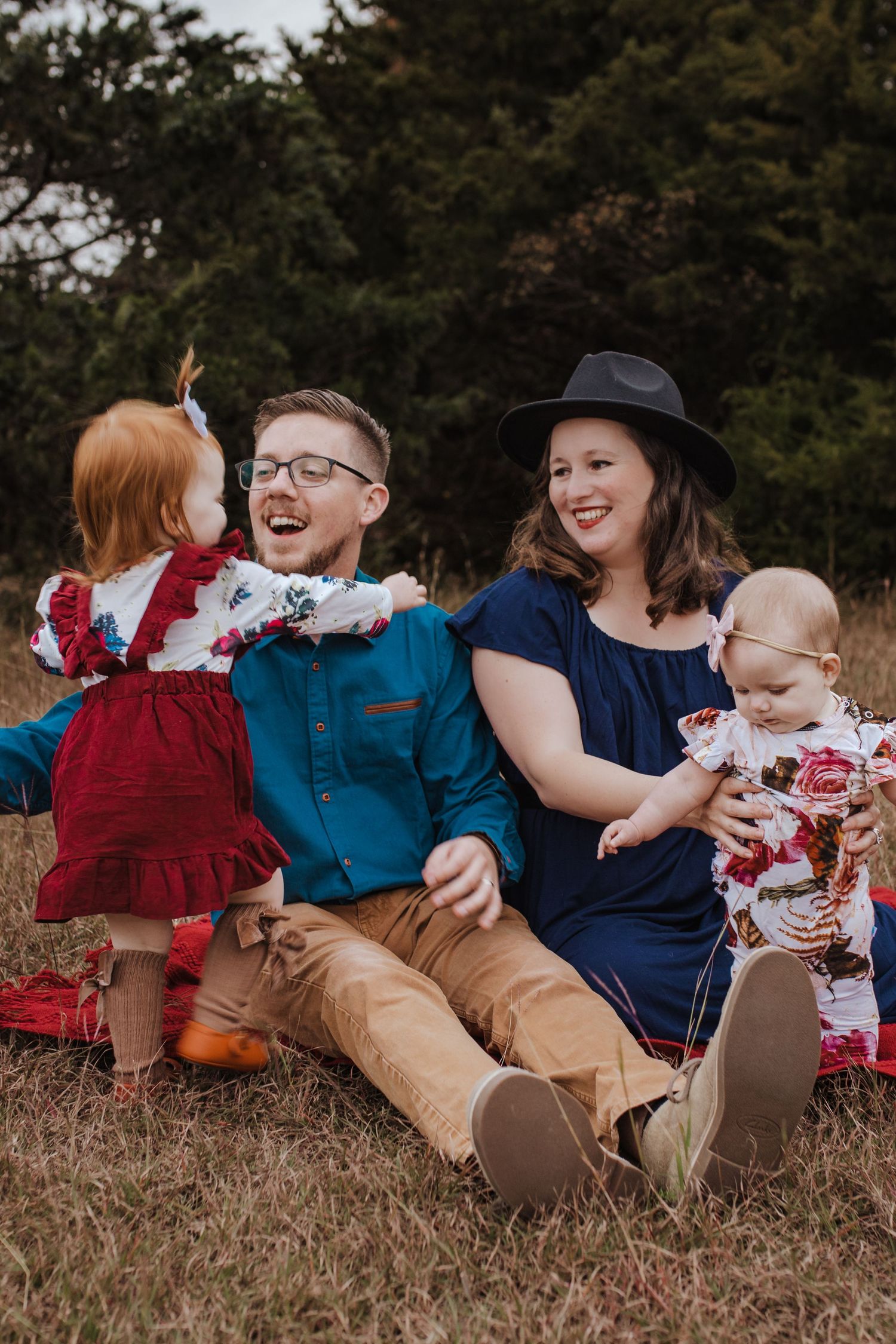 Family of four sitting in Pecan Grover Park