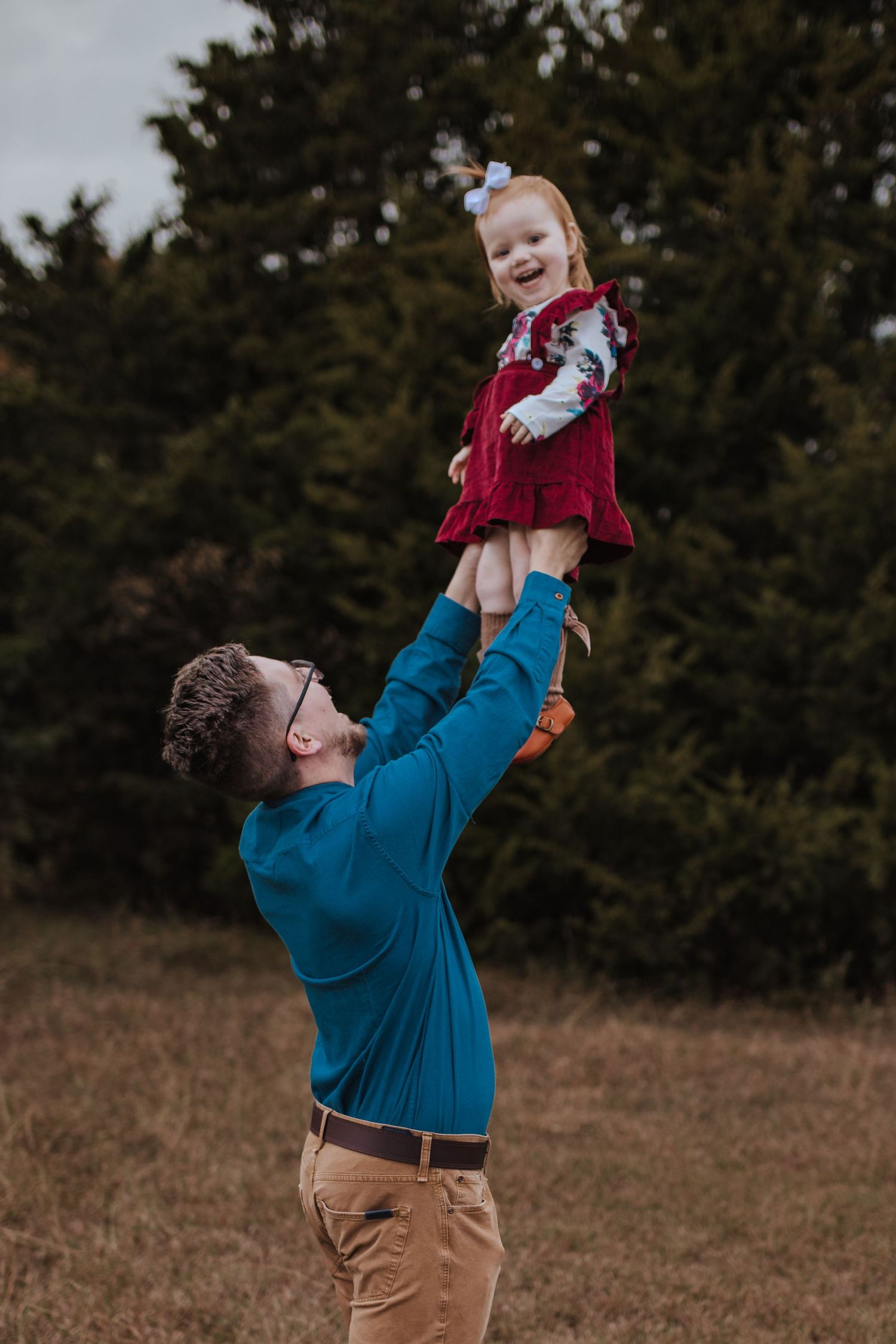 Dad holding daughter in the air near kids kingdom in rowlett