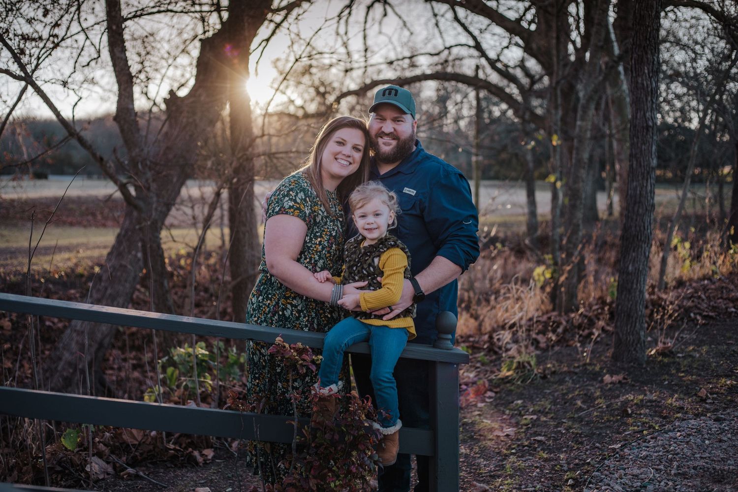 Family of three standing together at Golden hour