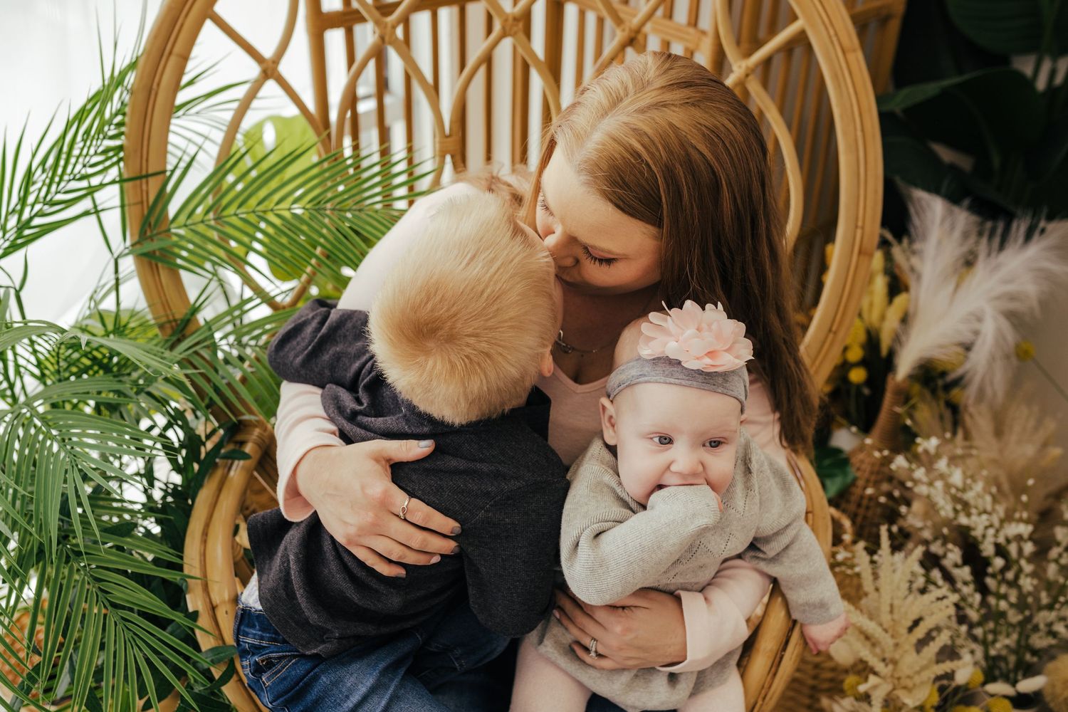 Mom with her two kids snuggled up in a whicker chair