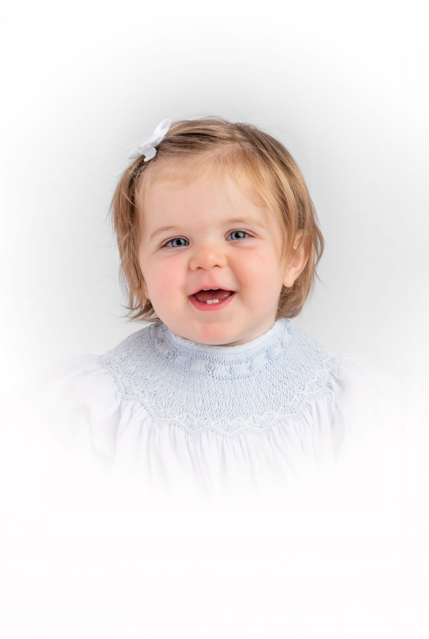 Heirloom portrait photograph of girl in blue smocked dress taken at Star Jamison photography studio.