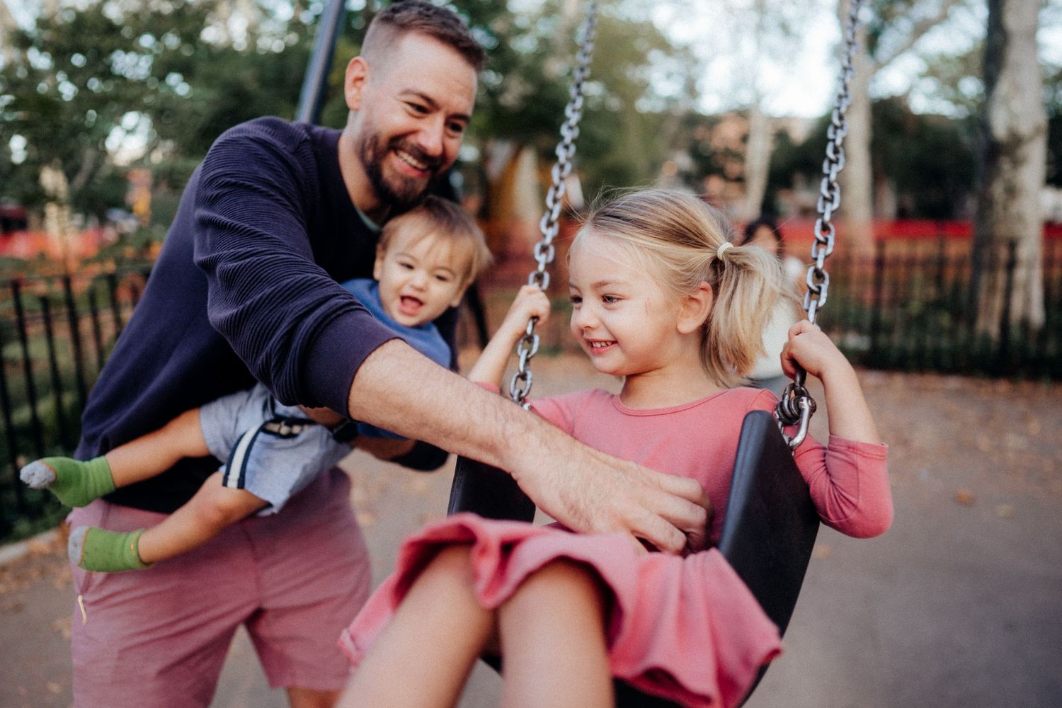 Joyful moment at playground with people playing on swing set.