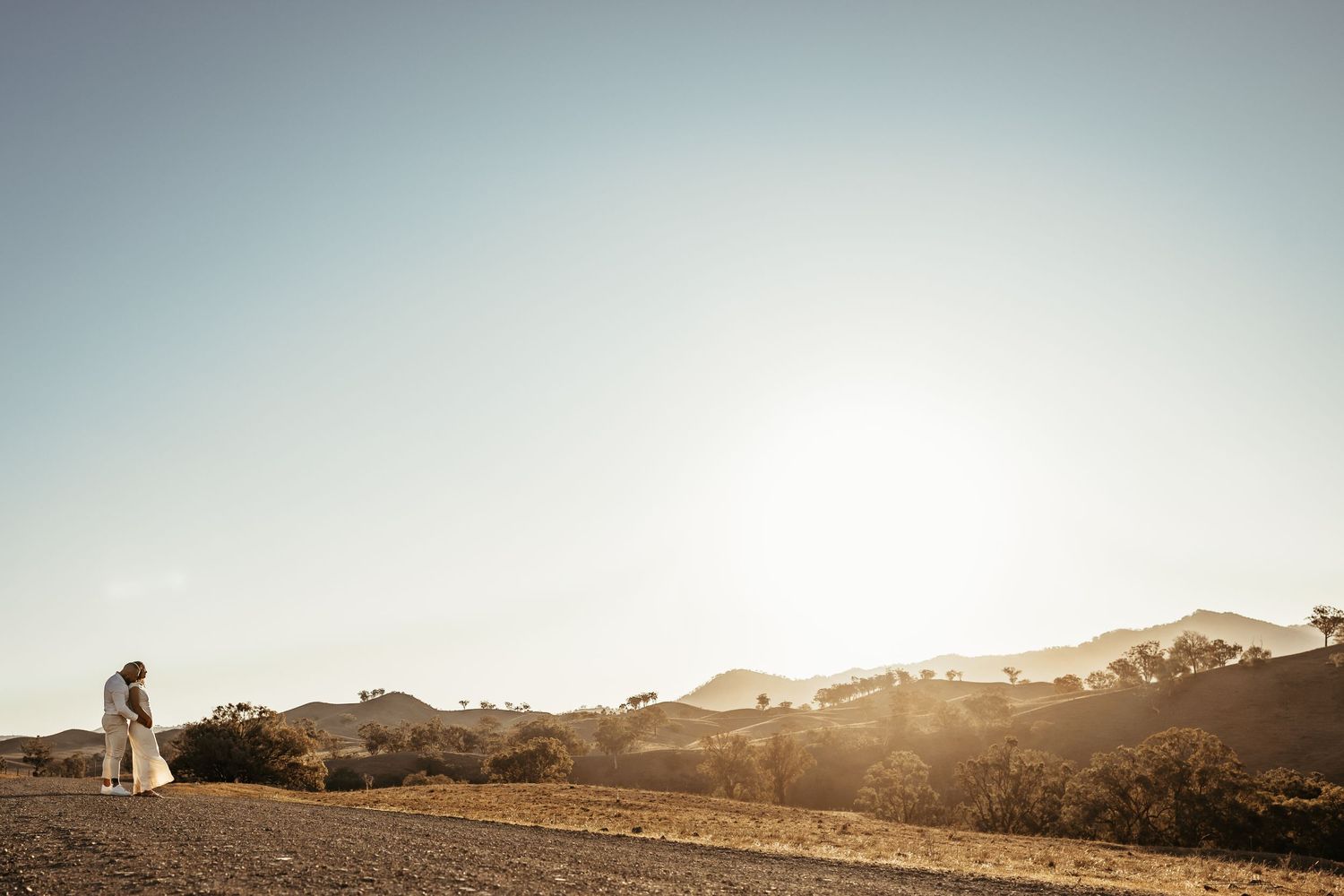 Panoramic view of desert landscape with mountains and soft sunset lighting.