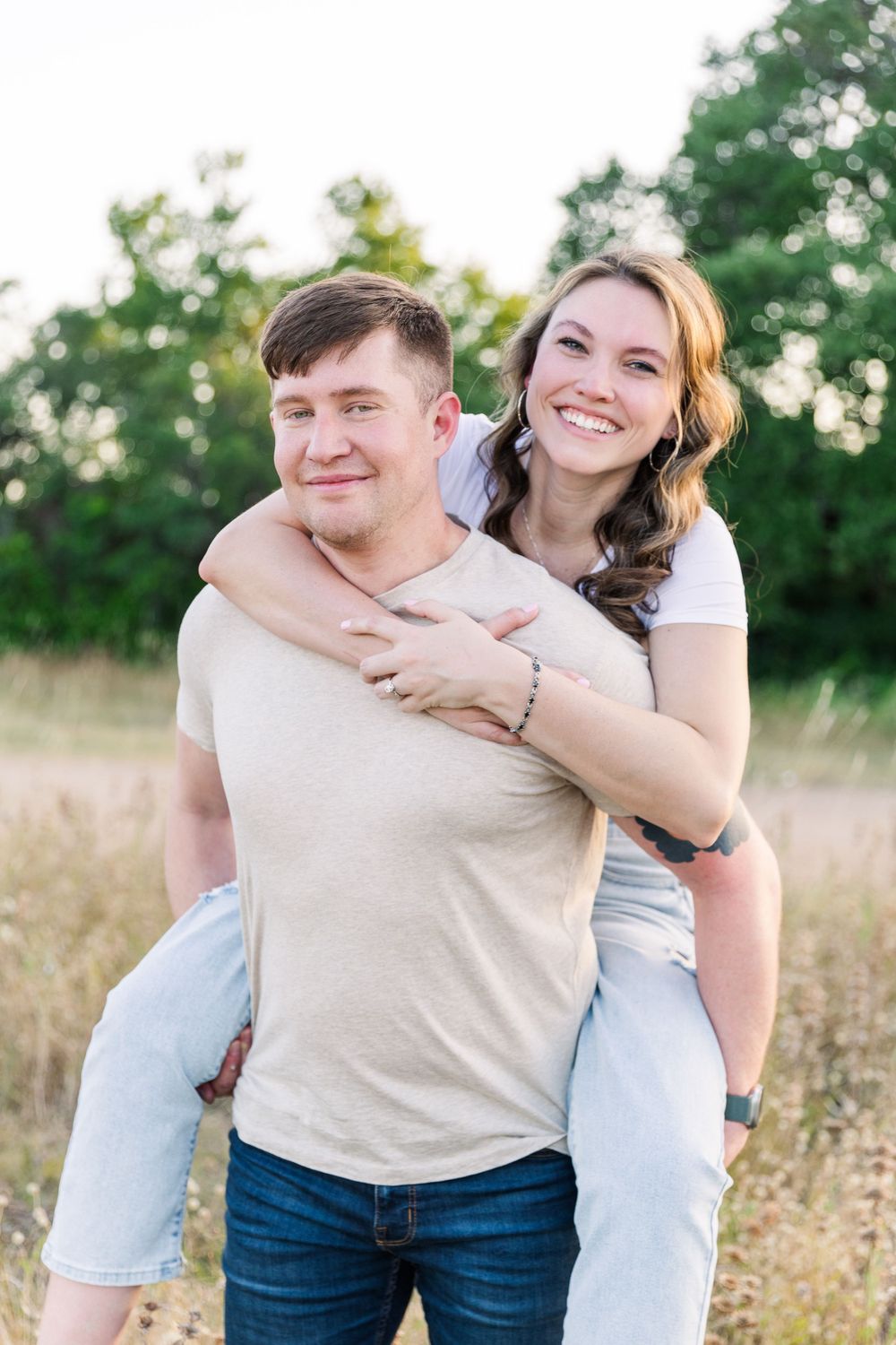couple piggyback ride in grassy field at Brushy Creek Lake Park