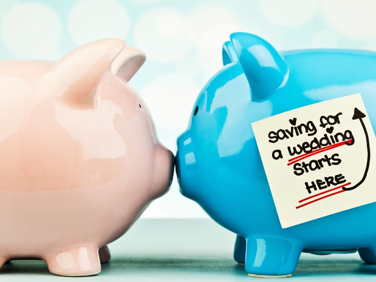 Two ceramic piggy banks facing each other symbolizing saving for wedding planning.