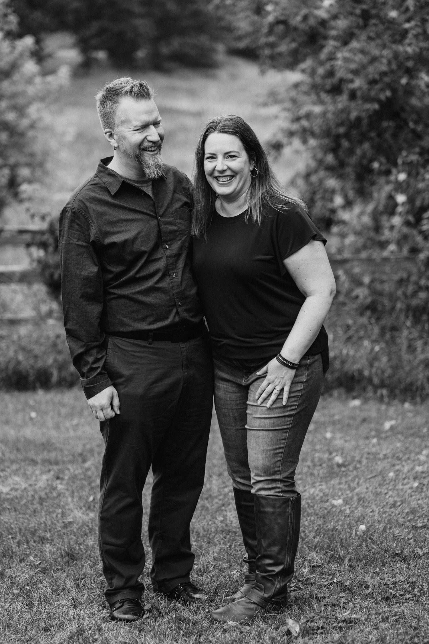 Black and white outdoor portrait session with matching dark outfits in natural setting.