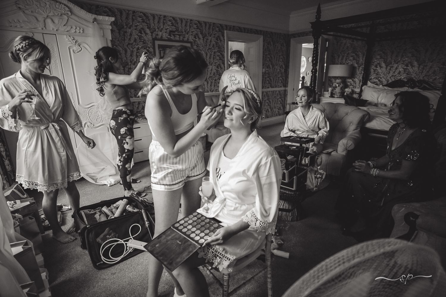 Bridal preparation in Trunkwell House, everyone is busy getting their hair and make up done, wedding photography.