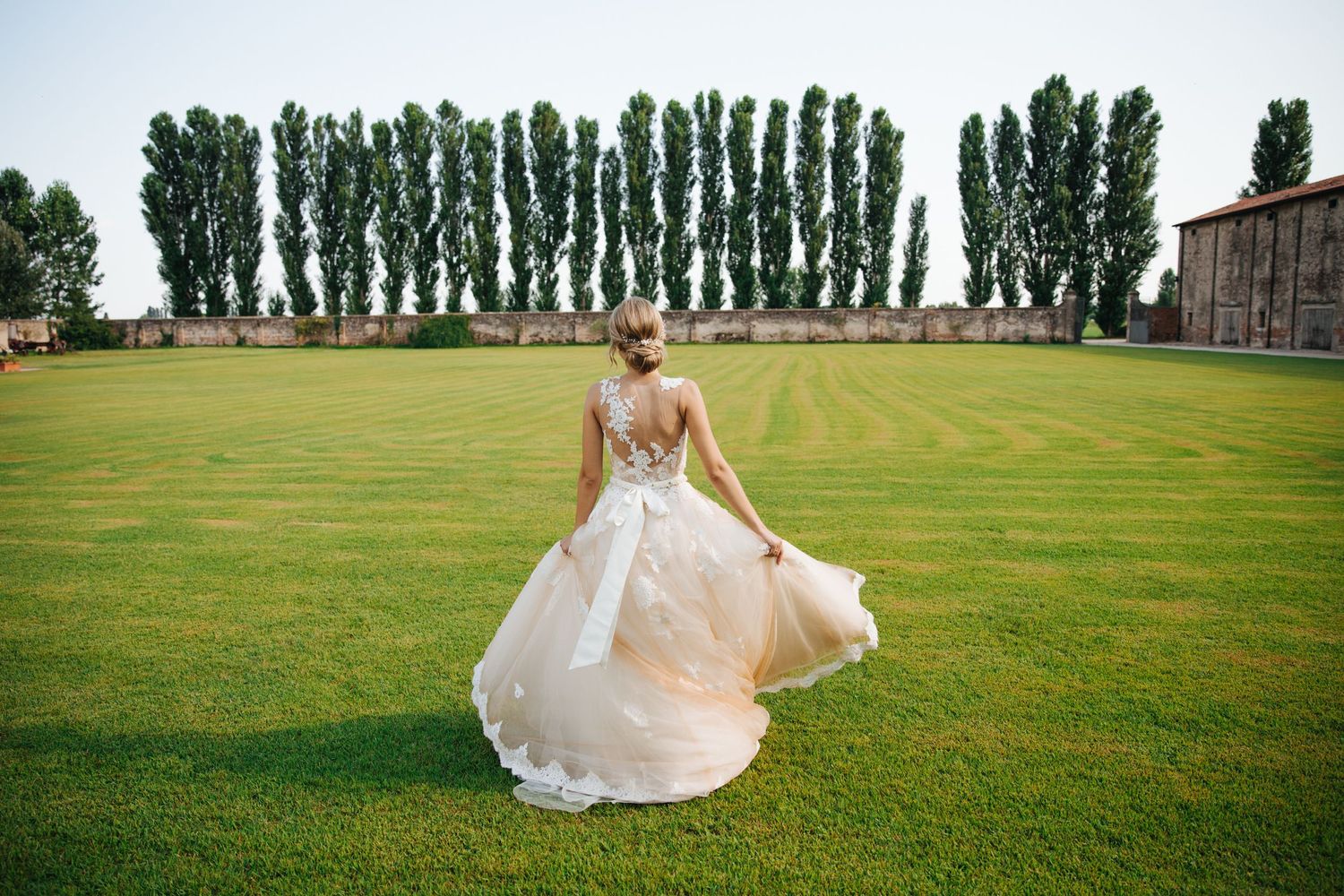 Bride gracefully by herself at an open field