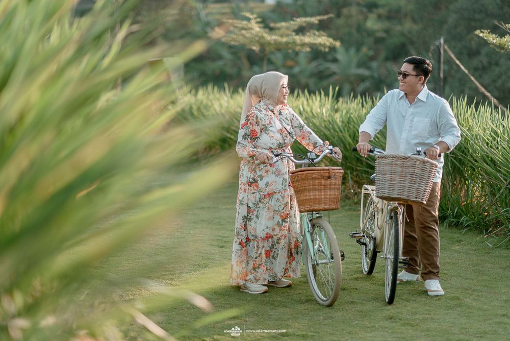 A couple with vintage bicycles and baskets shares a moment on a scenic nature trail.