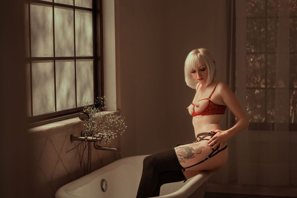A series of moody, sepia-toned photographs showing a figure in white against dark interior walls and window light.