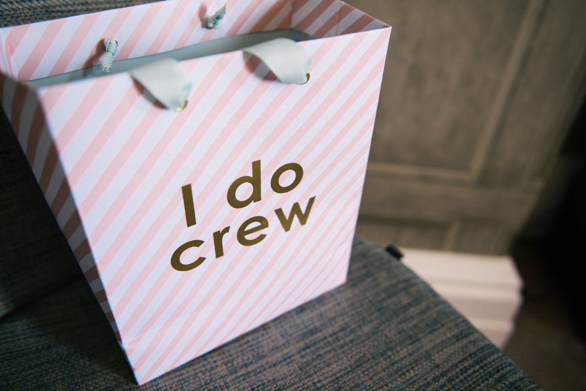 Pink and white striped gift bag with 'I do crew' text in gold lettering.