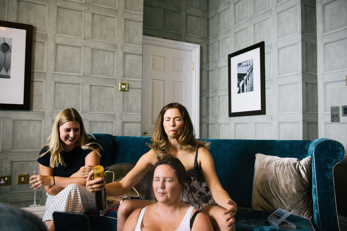 Friends relaxing together on a blue couch in a room with paneled walls.