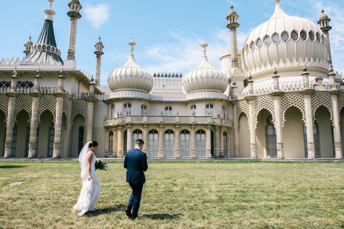 Couple walking towards Brighton Royal Pavilion with its distinctive Indian-inspired architecture.