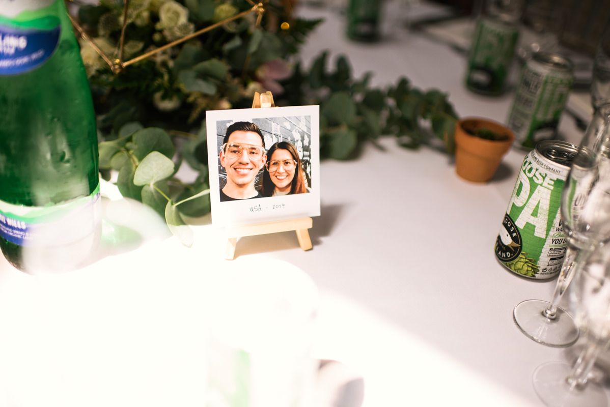 Small photo display on easel among table decorations at wedding reception.