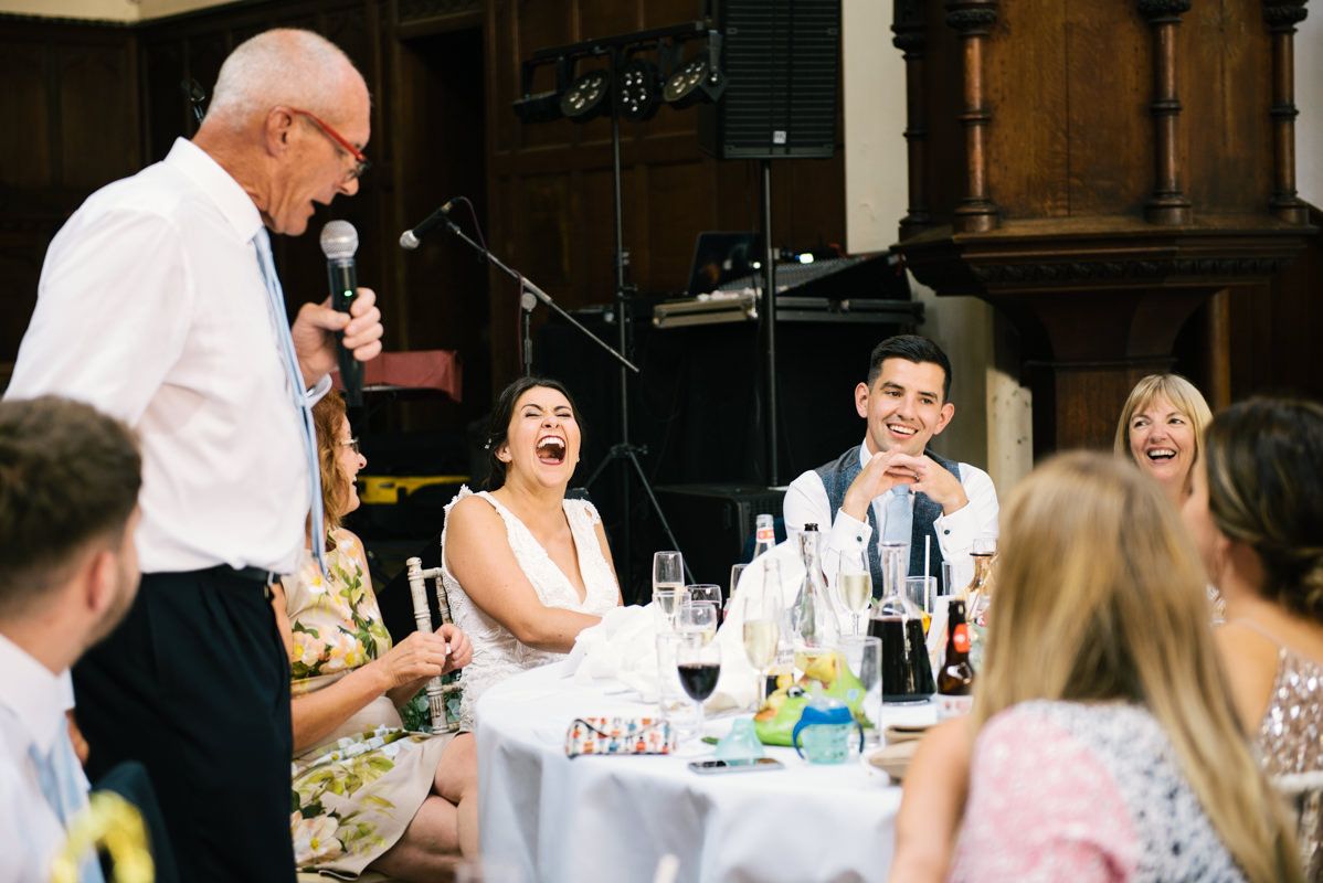 Wedding reception speech being delivered at an elegant indoor celebration.