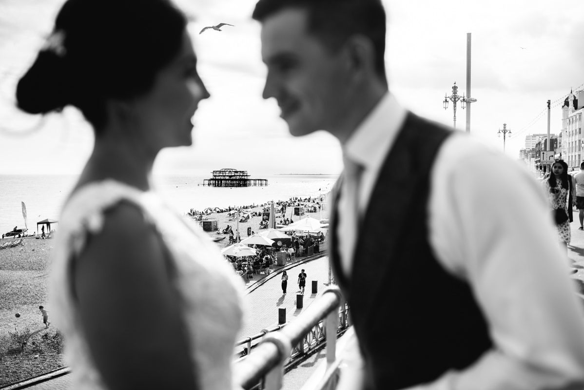 Romantic black and white seaside portrait with pier and beach in background.