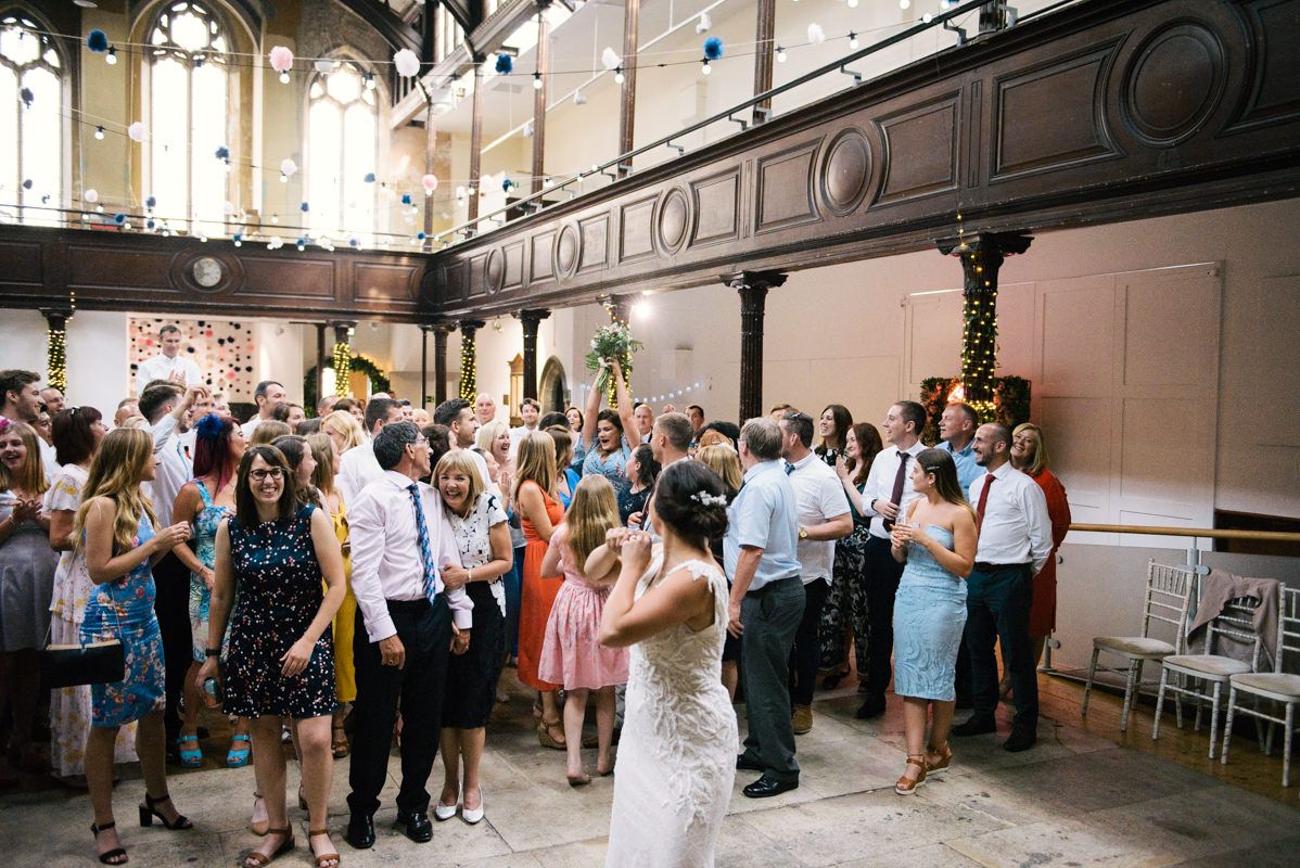 Wedding celebration in historic venue with guests dancing and mingling.