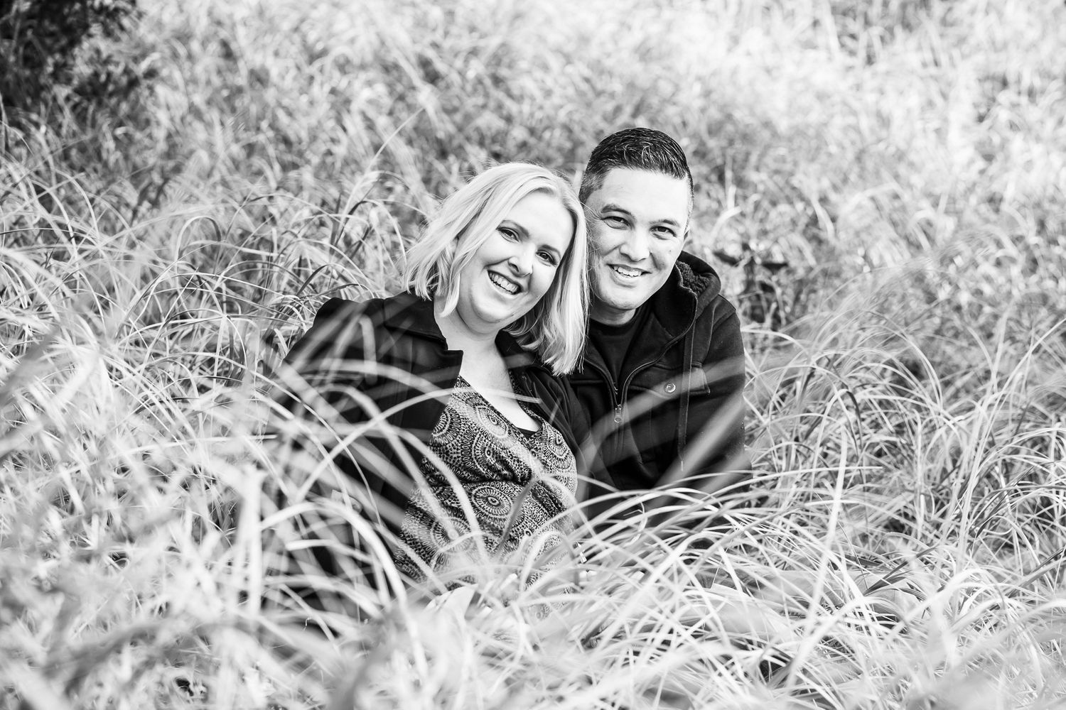 A gorgeous couple sit and relax at Muriwai Beach