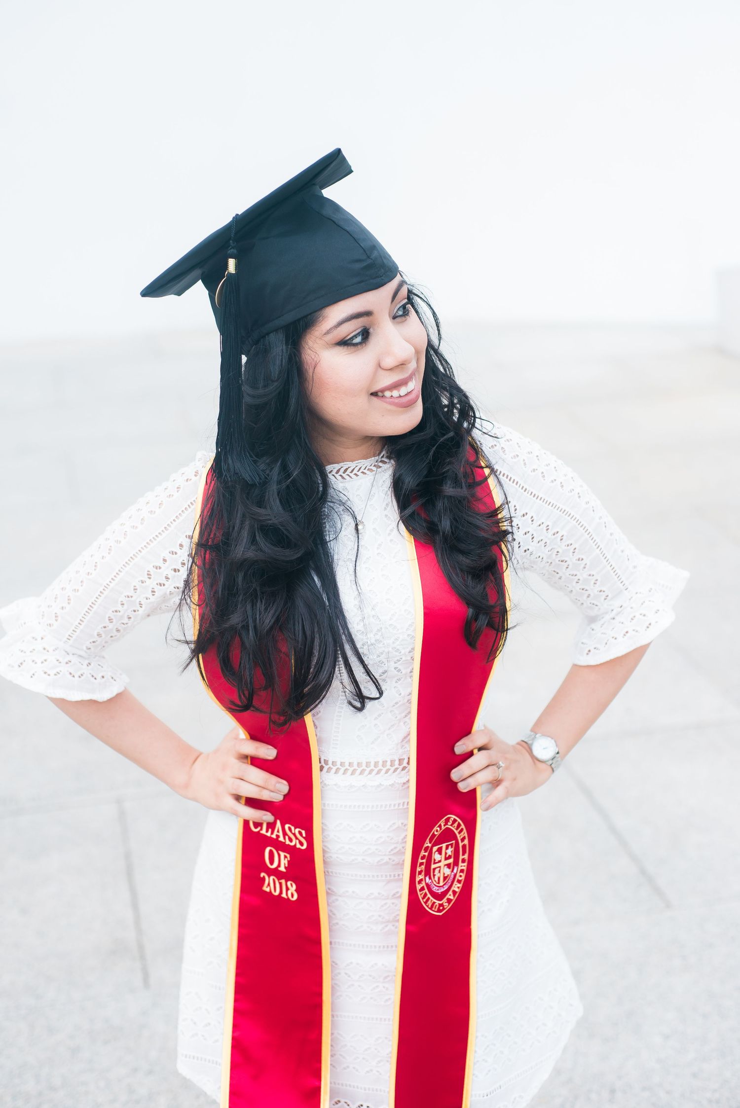 woman wearing a red graduation sash and cap for senior portraits