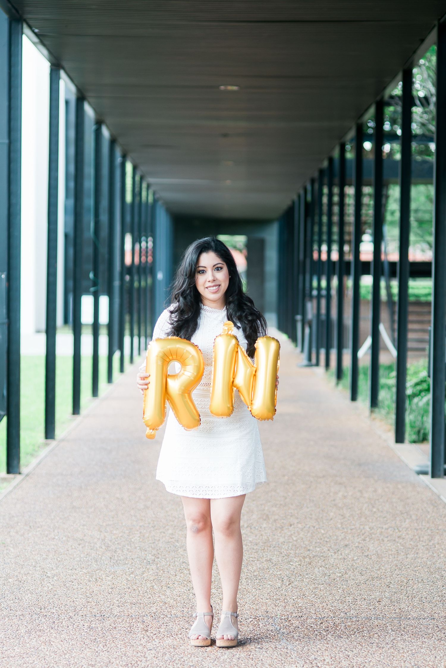 senior graduate holding rn balloons