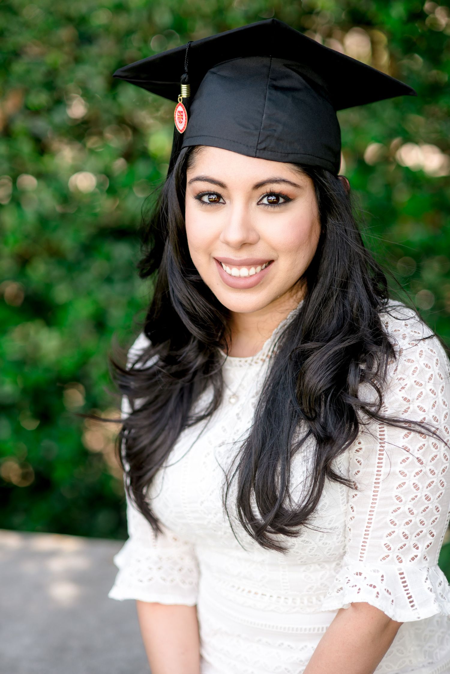 portrait of a woman wearing her graduation cap at a park