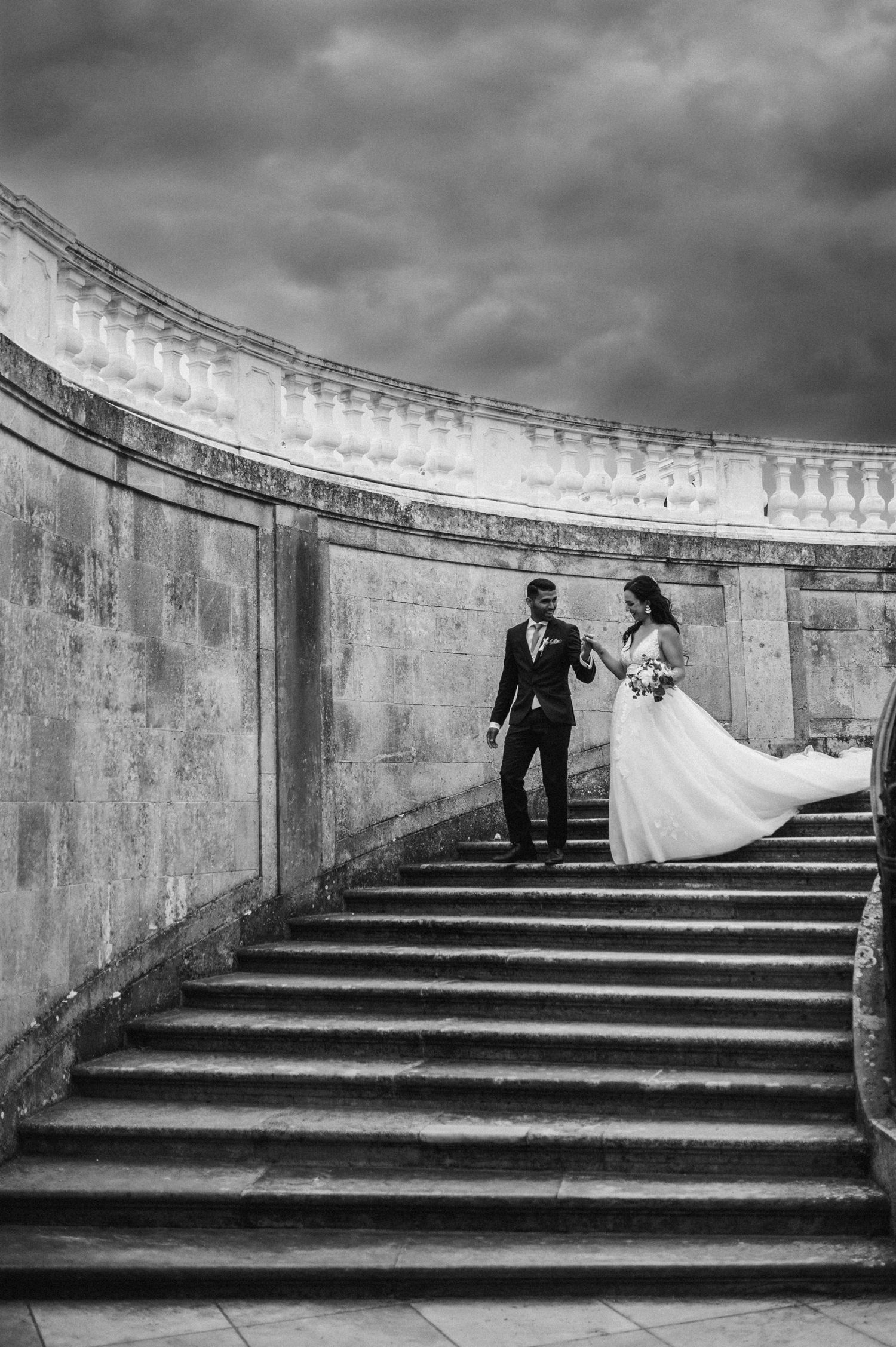 Bride from Philippines  and Indian groom walking down the stairs at castle near Vienna, Austria.