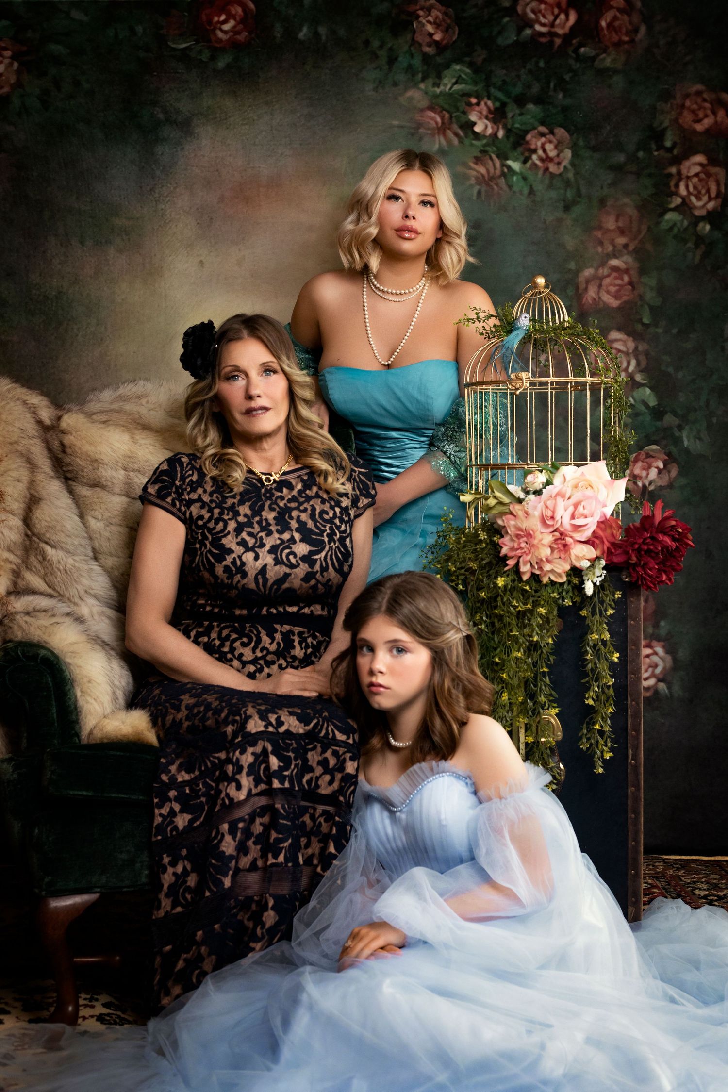 Vintage-inspired portrait with birdcage props, roses, and elegant formal dresses.