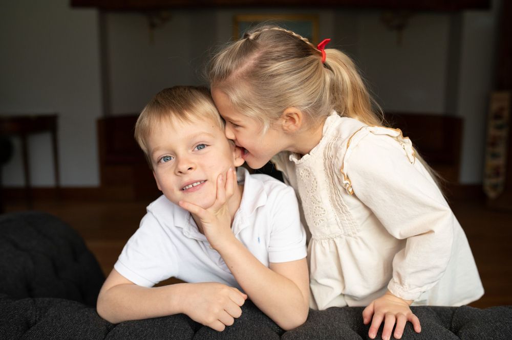 Whispering secrets between siblings during a family photoshoot.