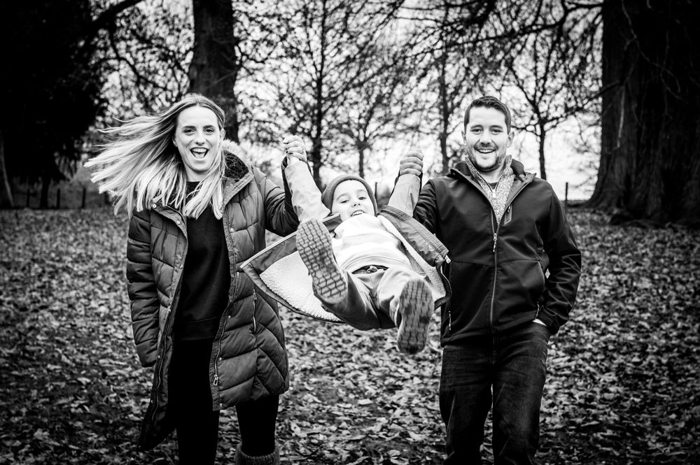 1,2,3 swing! Mum and dad swinging their 5 year old during a winter walk.